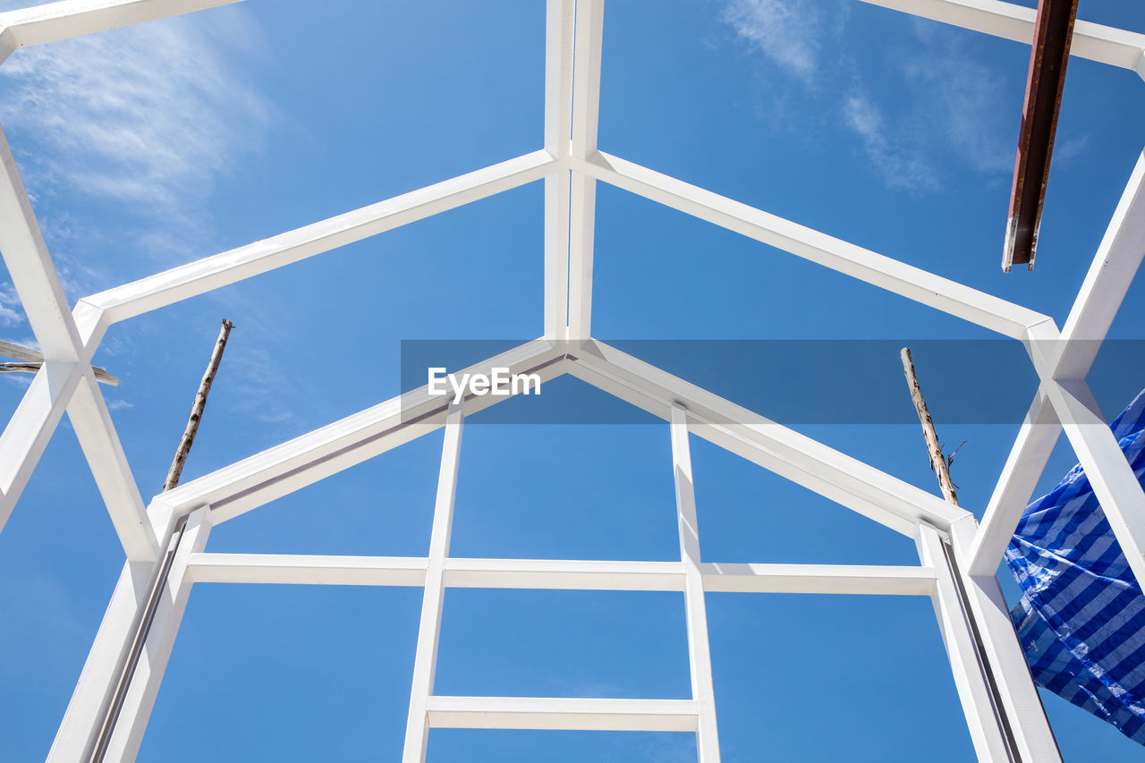 New house construction with white steel frame structure, blue sky