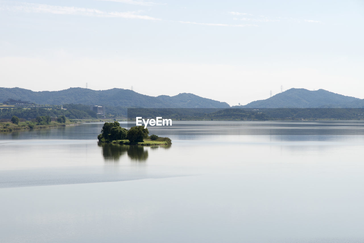 SCENIC VIEW OF LAKE BY MOUNTAIN AGAINST SKY