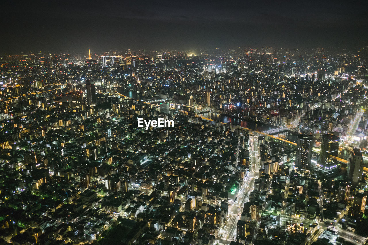 Illuminated cityscape against sky at night