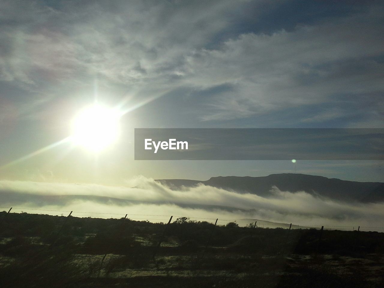 Scenic view of landscape against cloudy sky