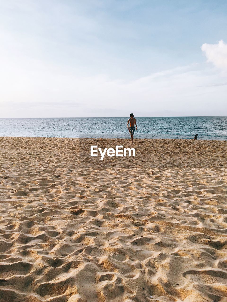 MAN ON BEACH AGAINST SKY