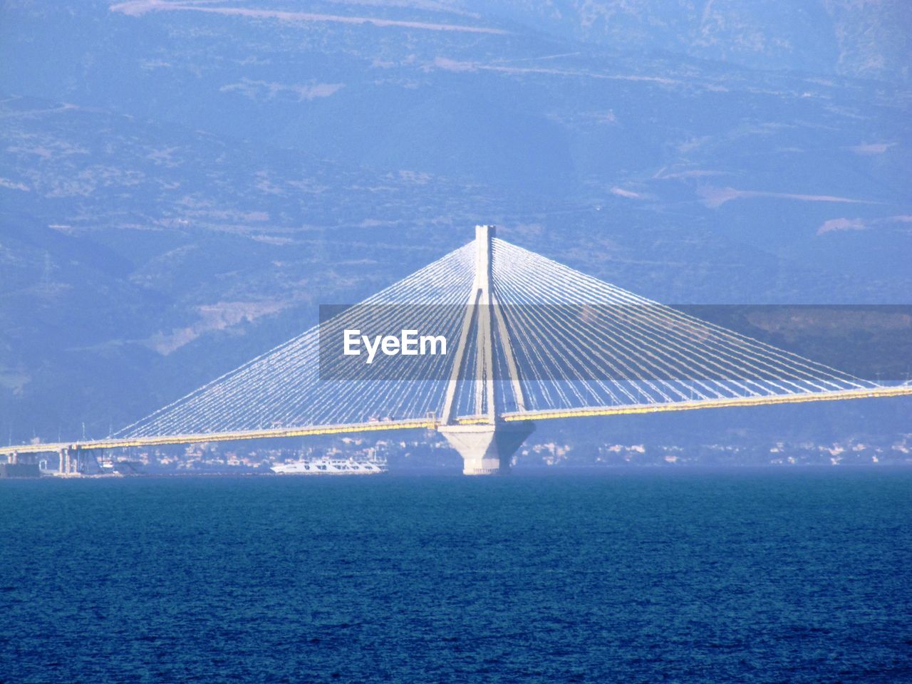 Suspension bridge over sea against sky