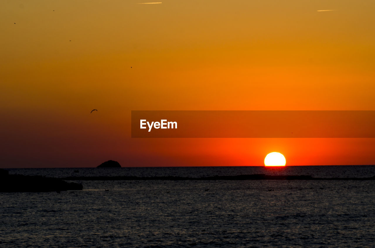 SCENIC VIEW OF SEA AGAINST SKY AT SUNSET