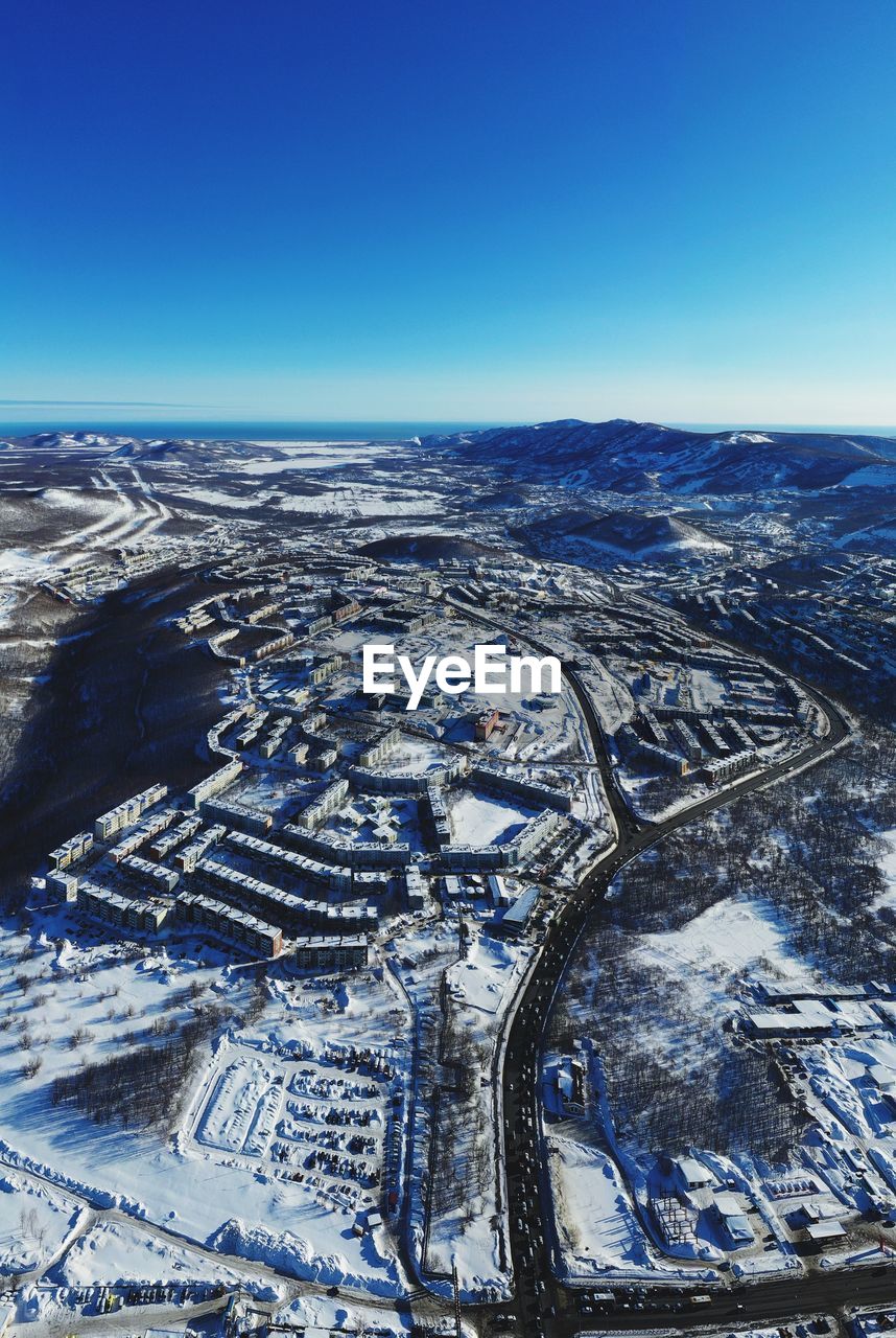 High angle view of snowcapped landscape against clear blue sky