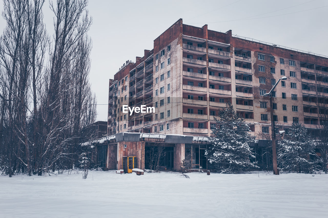 Buildings in city against sky during winter