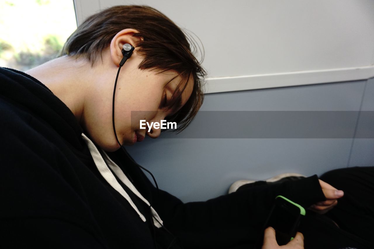 Solo traveler asleep on the bus with earphones