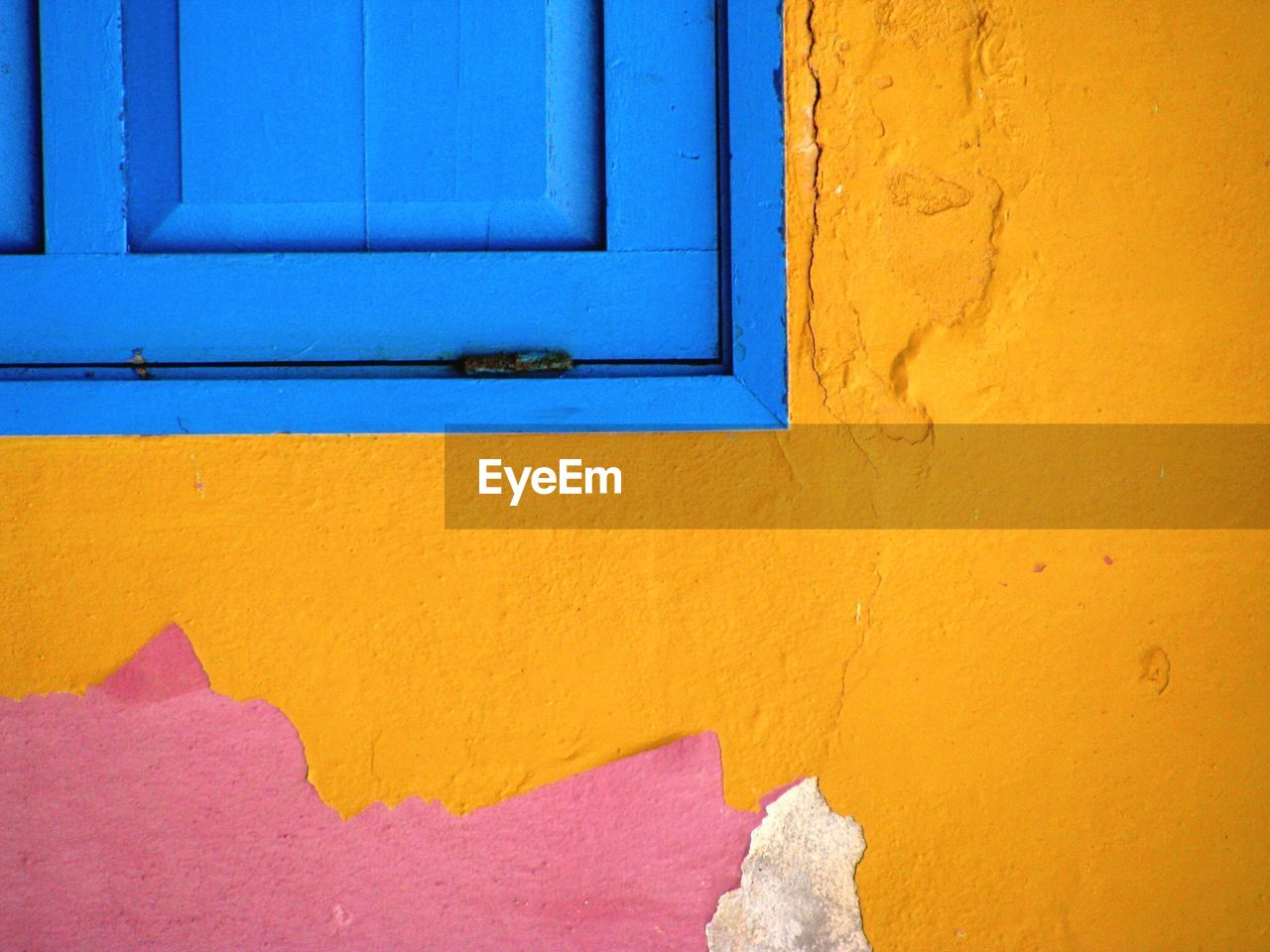 FULL FRAME SHOT OF MULTI COLORED WALL WITH YELLOW DOOR