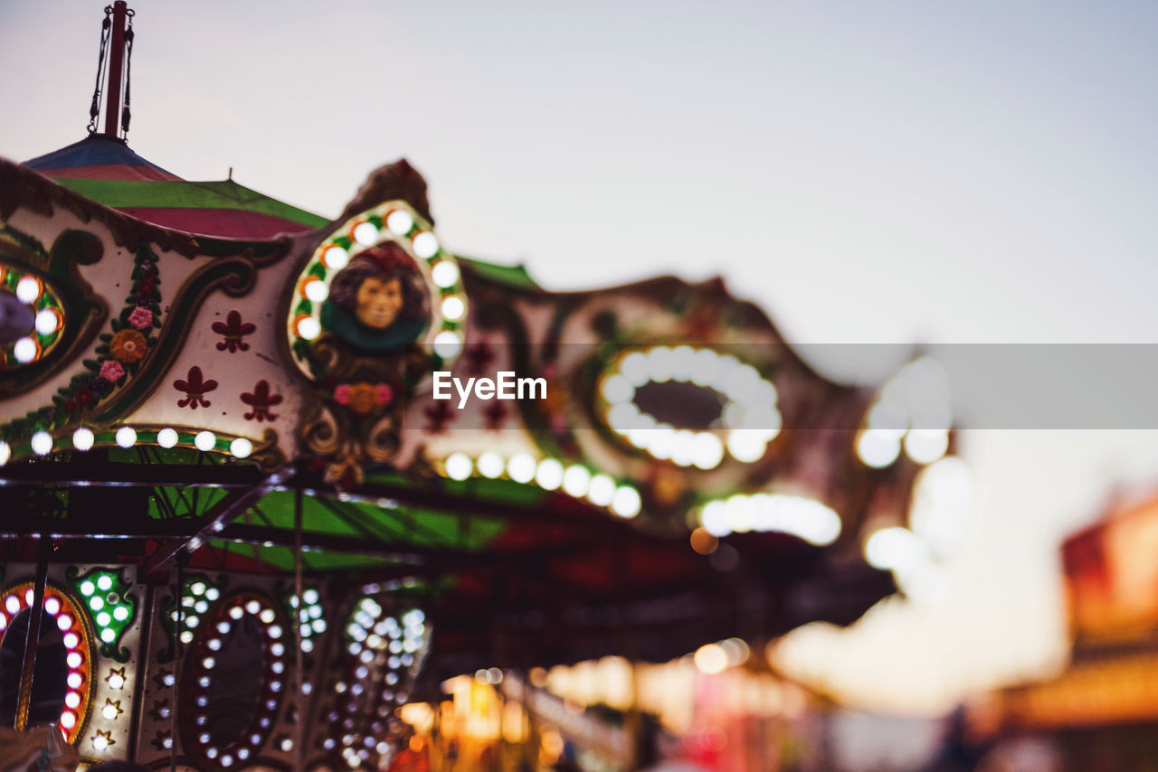 Low angle view of illuminated carousel against sky