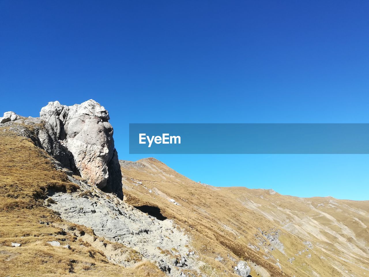 Scenic view of rocky mountains against clear blue sky