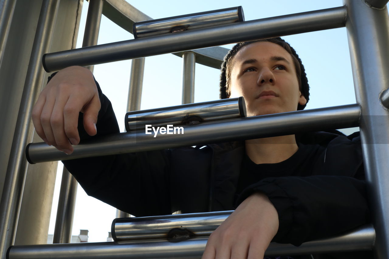 Man looking through metal bars