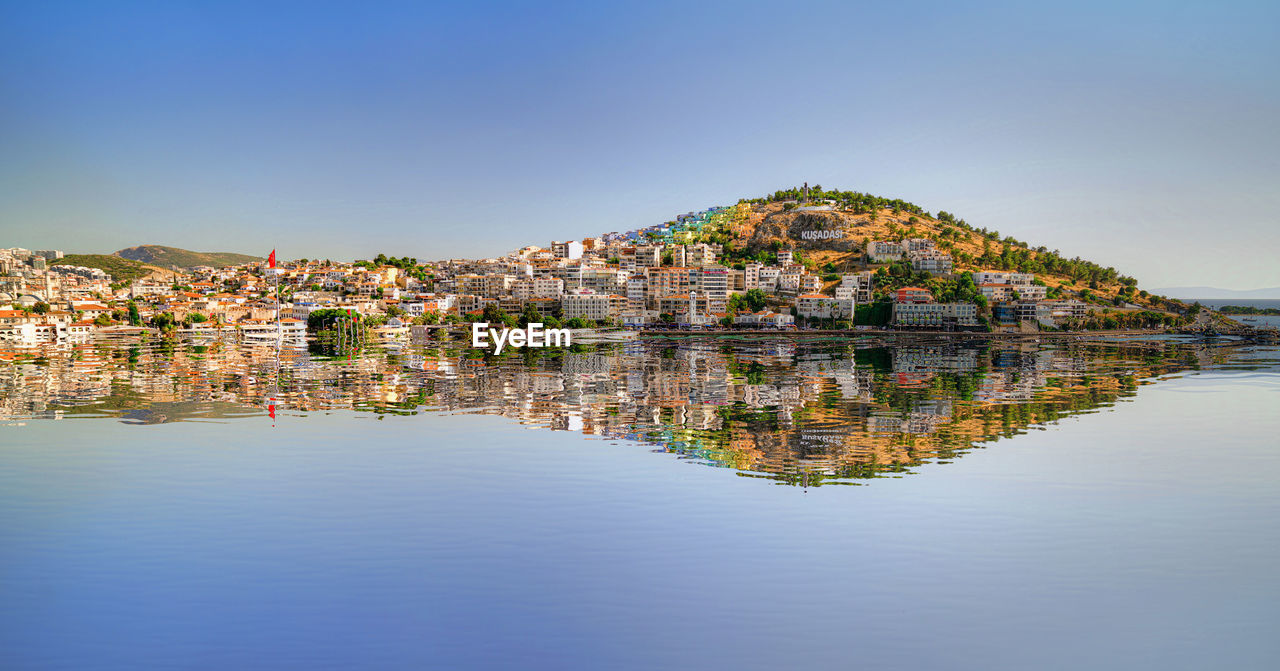 Panoramic shot of townscape by lake against sky