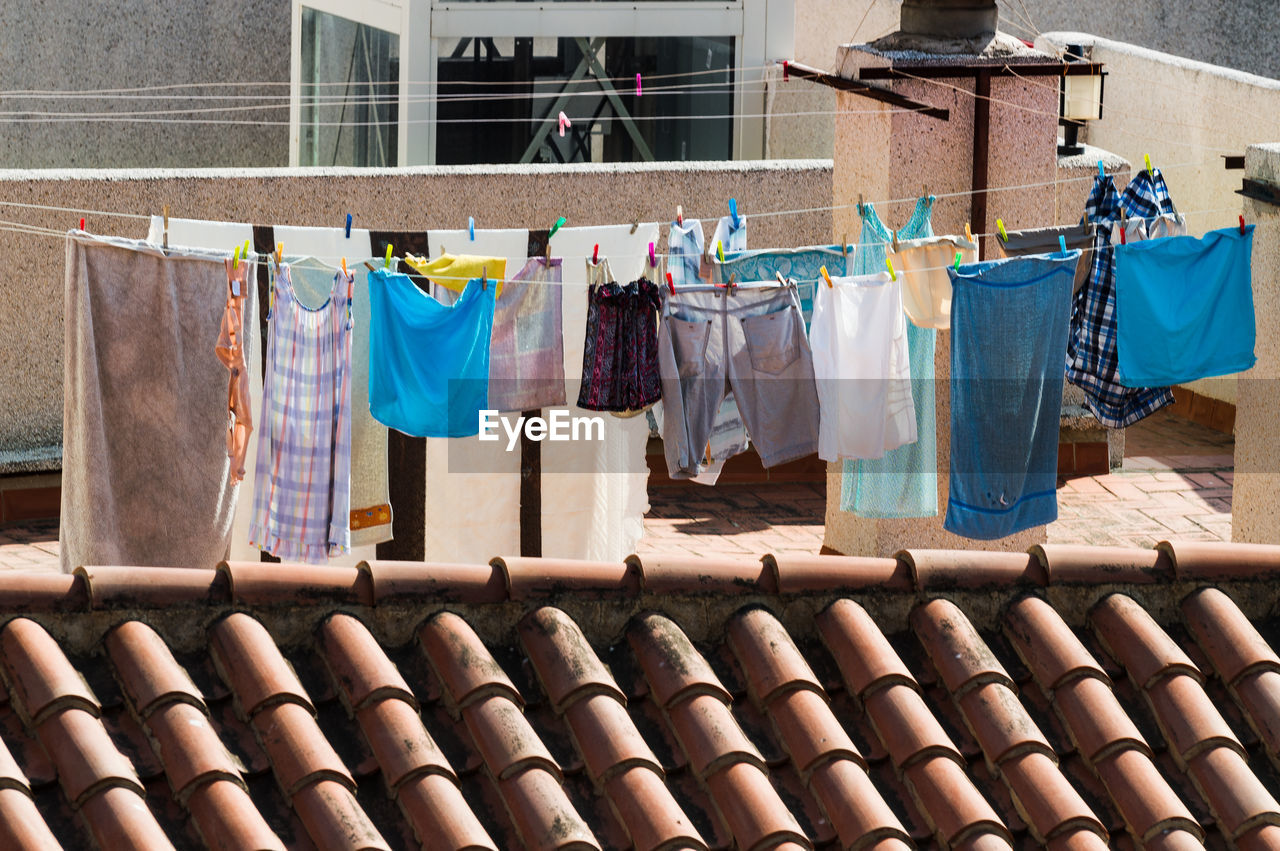 CLOTHES DRYING ON CLOTHESLINE OUTSIDE BUILDING