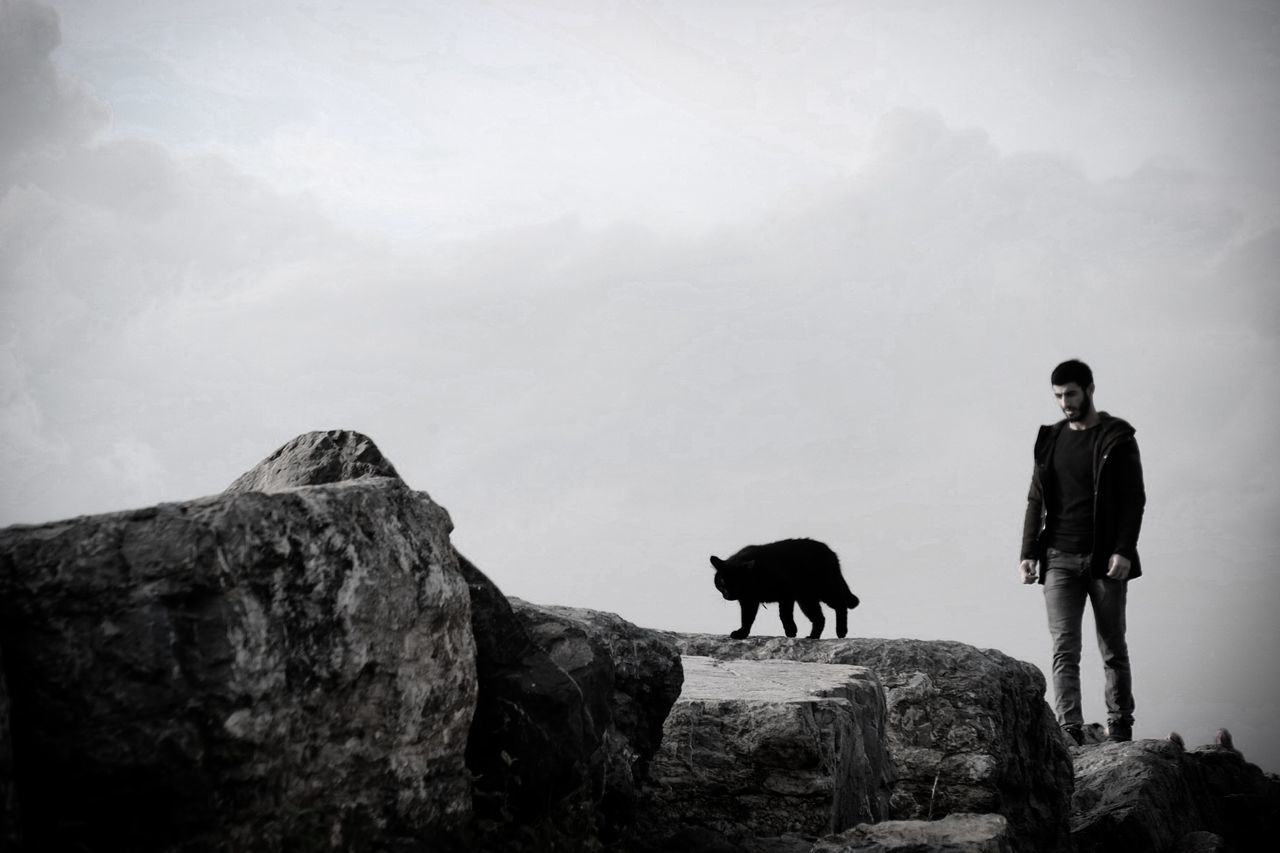 MAN STANDING ON ROCK