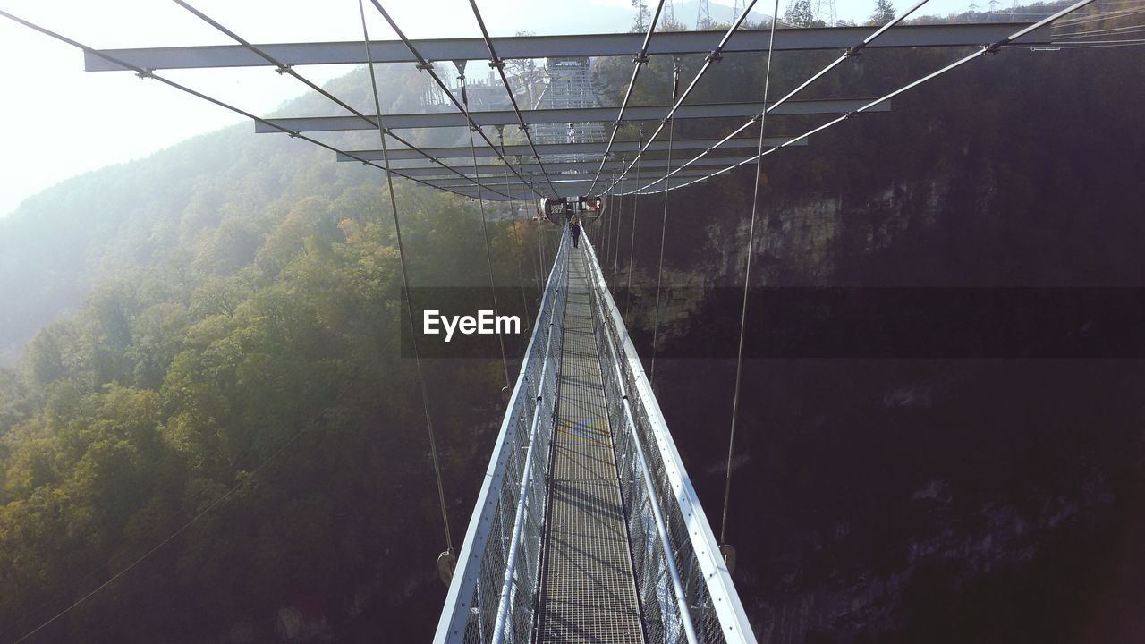 Footbridge against mountain at forest