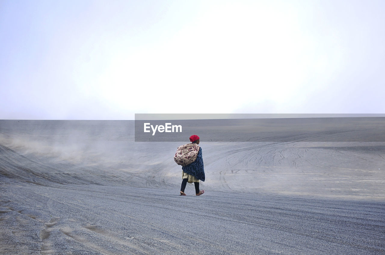 FULL LENGTH REAR VIEW OF MAN ON SNOWY LANDSCAPE