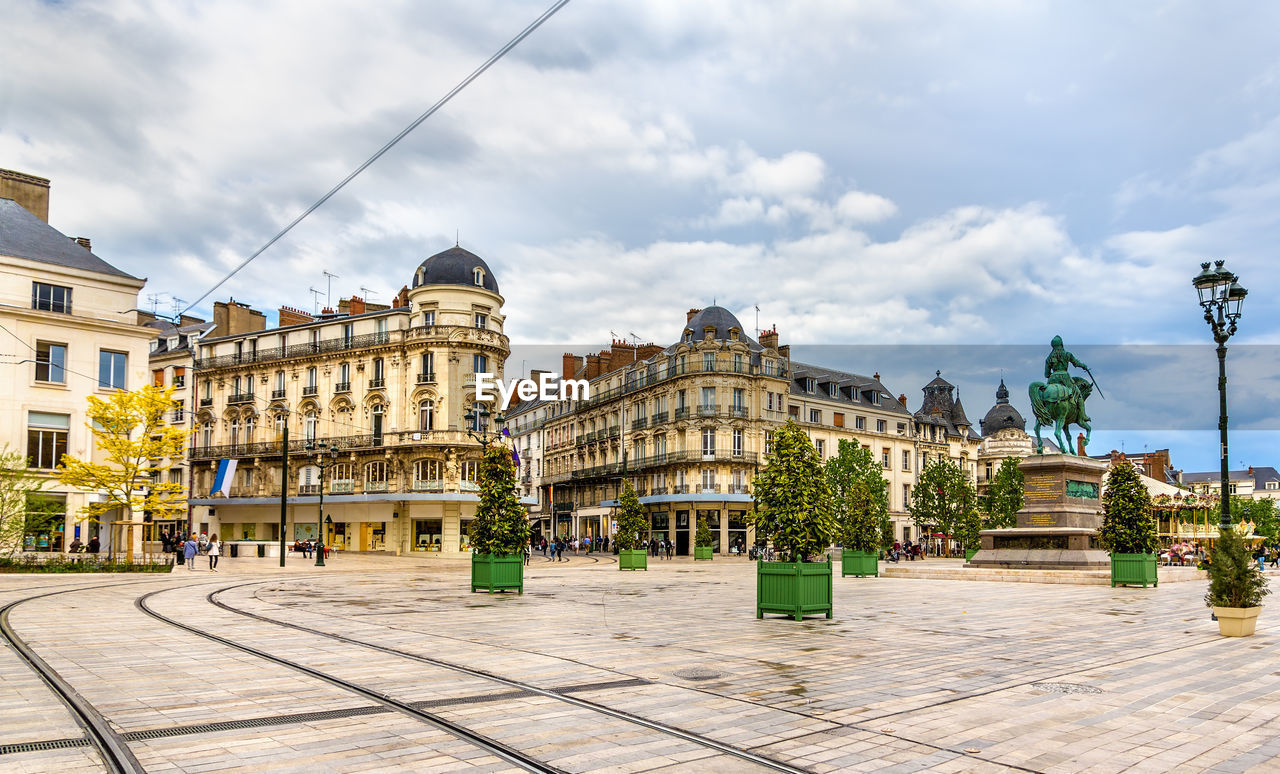 Buildings in city against cloudy sky