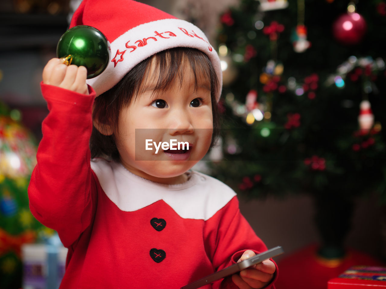 Cute girl wearing costume standing by christmas tree at home