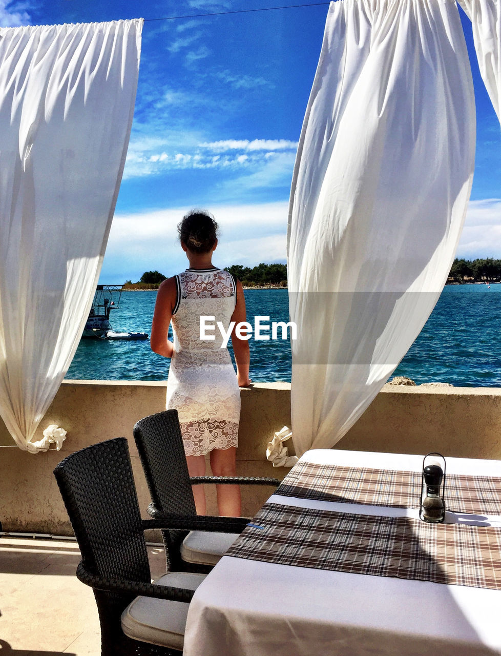 Rear view of woman looking at sea against sky