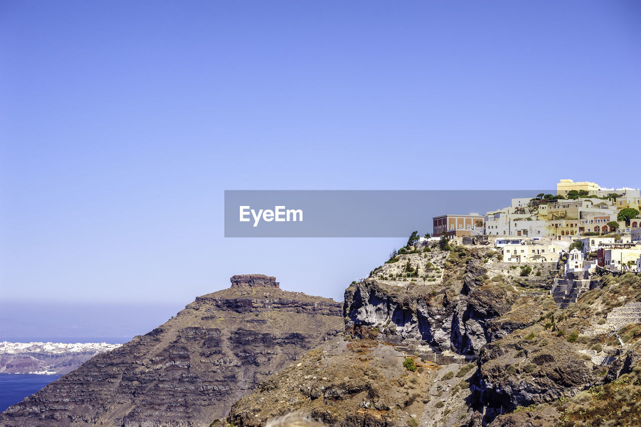 BUILDINGS ON ROCK AGAINST CLEAR BLUE SKY