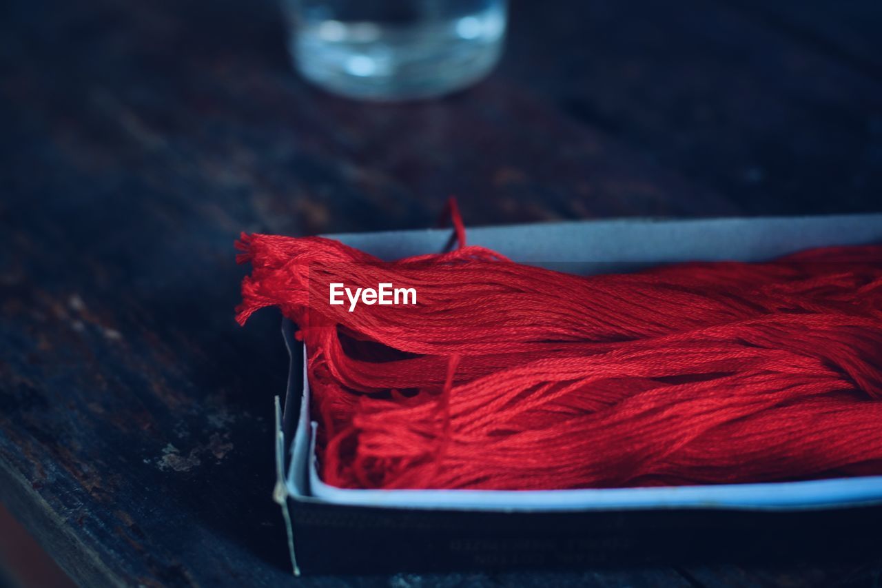 Close-up of red wool in box on table