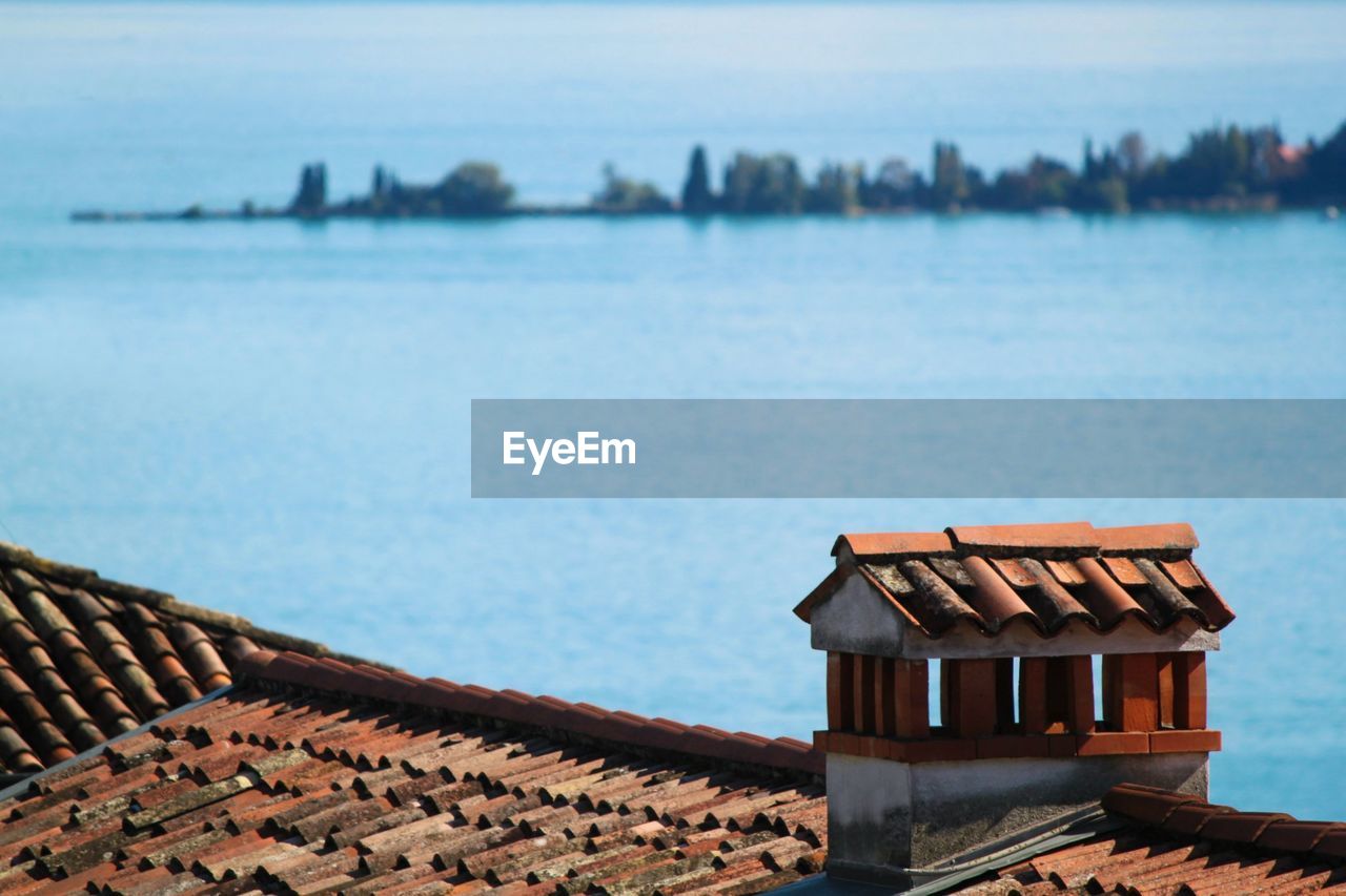 HOUSE ON SEA BY BUILDINGS AGAINST SKY