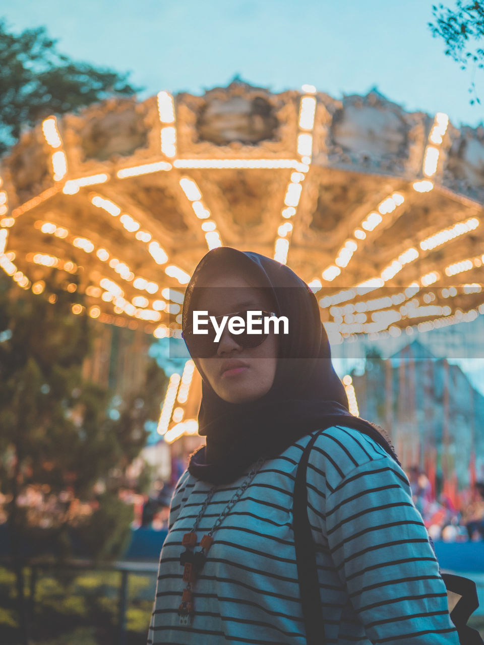 Close-up portrait of young woman in amusement park