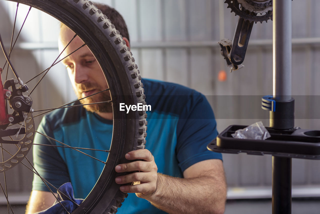 Mid adult man repairing bicycle at garage