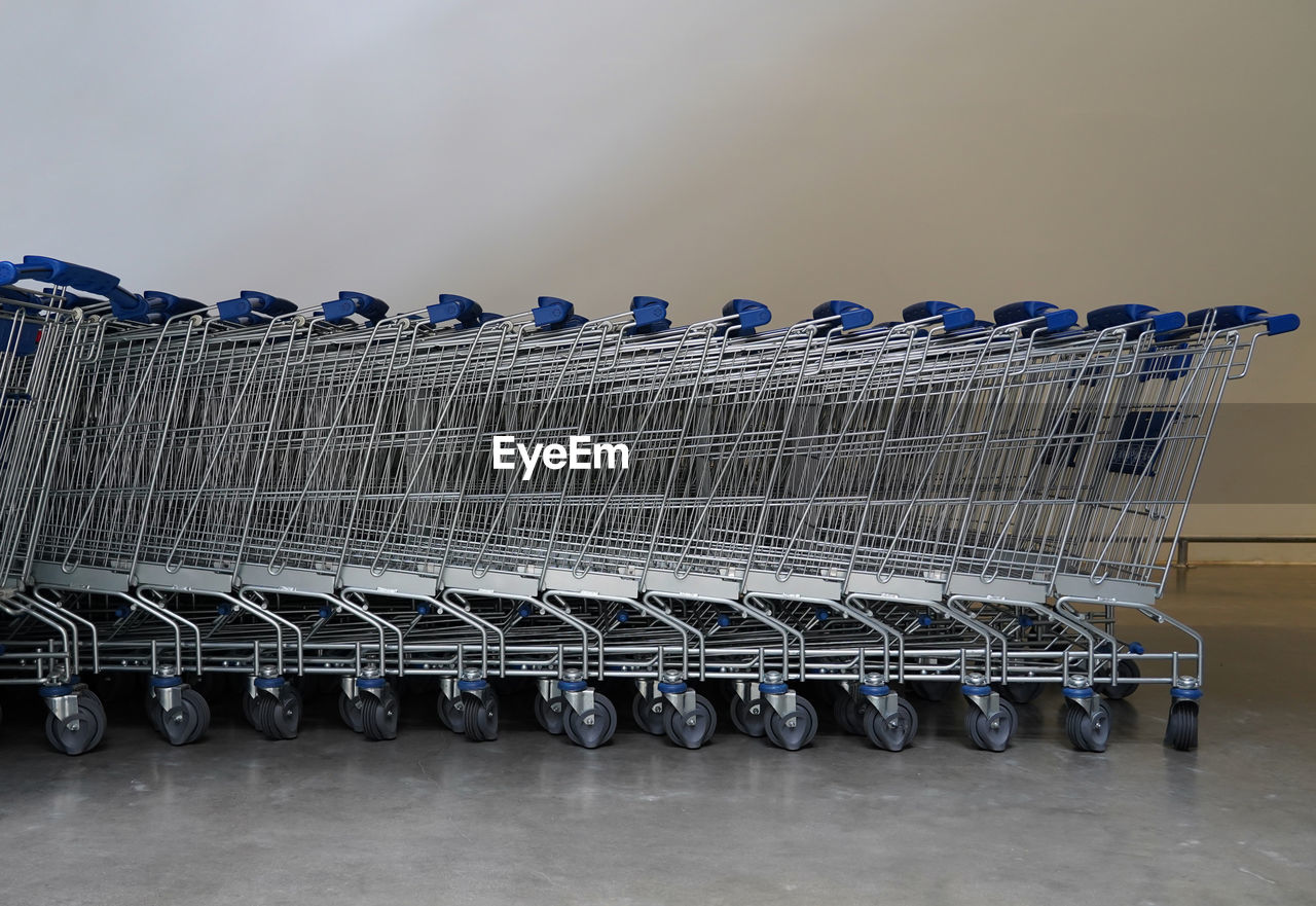 Close-up of shopping carts by wall