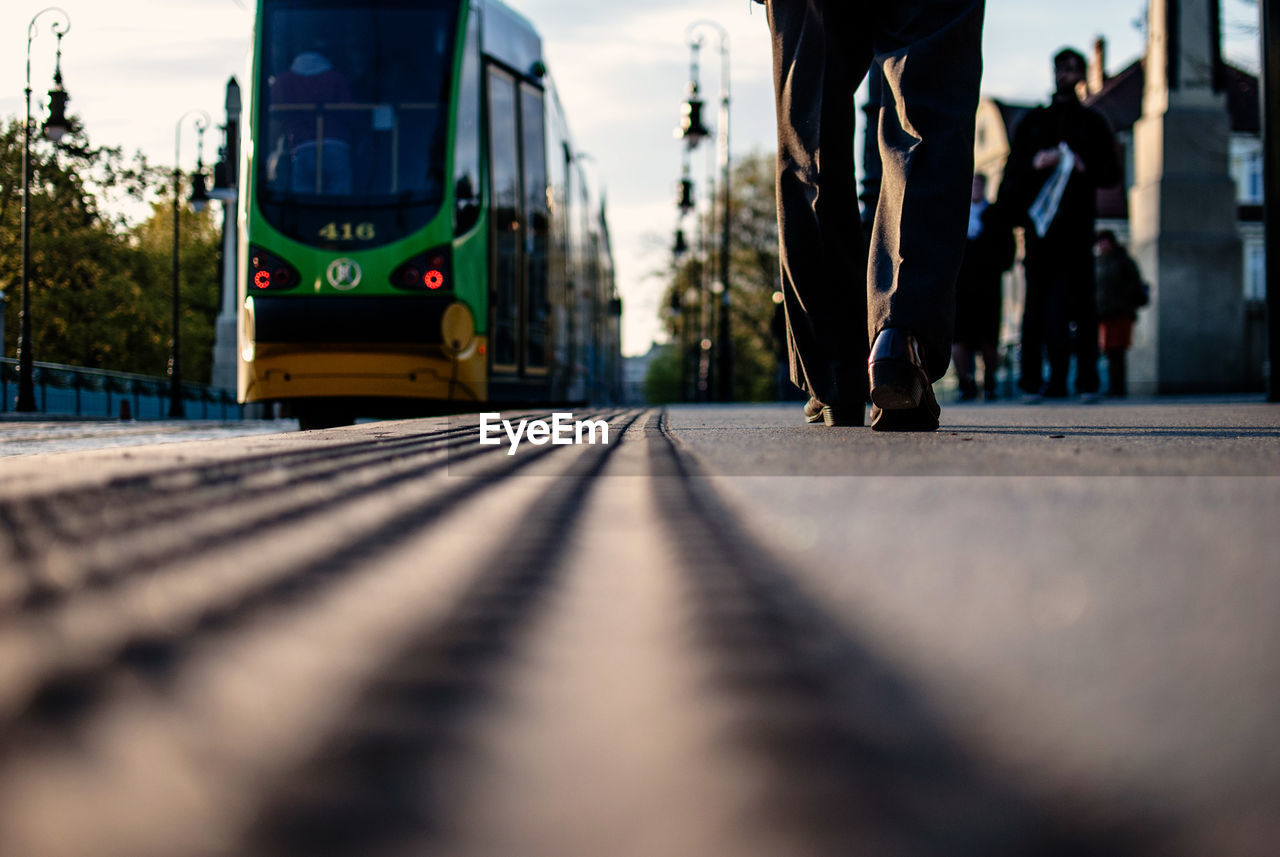 Surface level of man walking by tramway