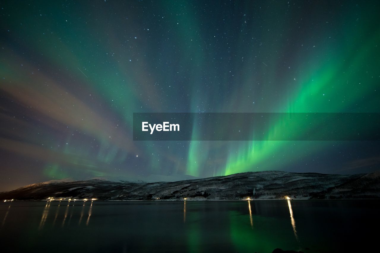 Scenic view of lake against sky at night