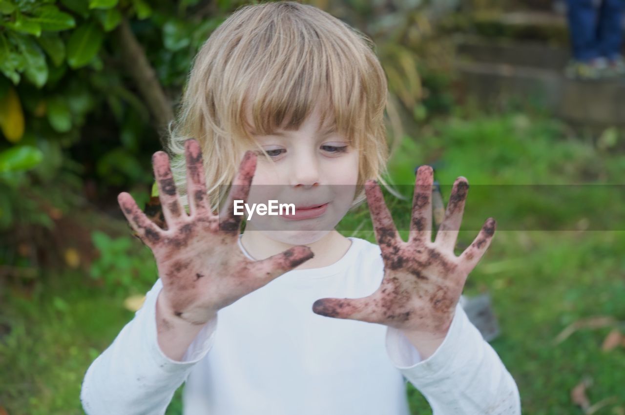 Portrait of happy girl with muddy hands