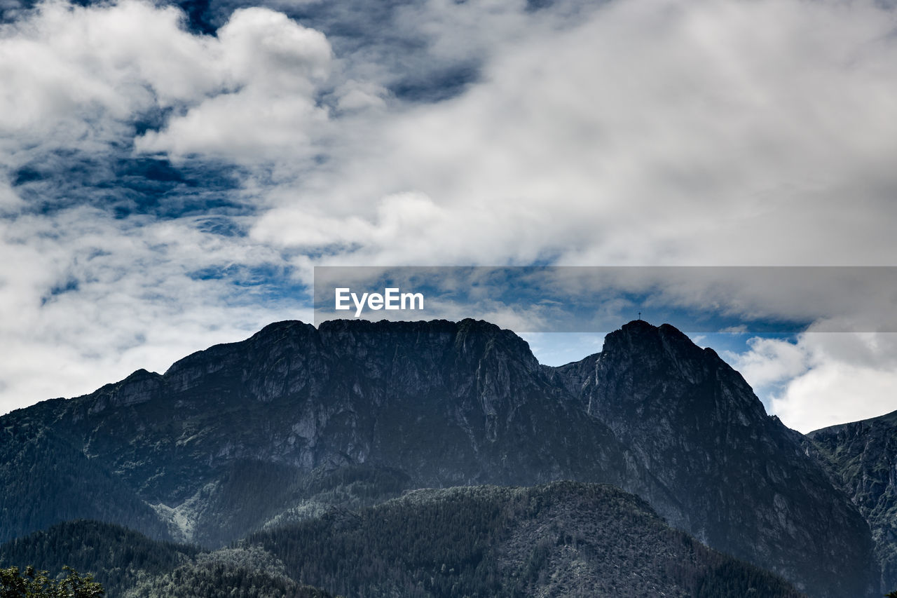 Low angle view of mountain against cloudy sky