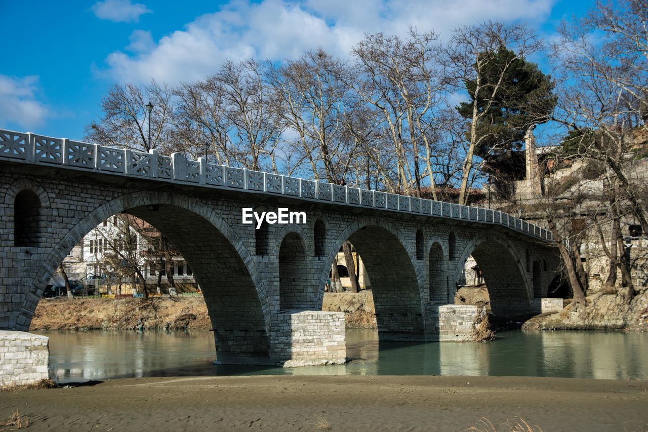 Arch bridge over river against sky