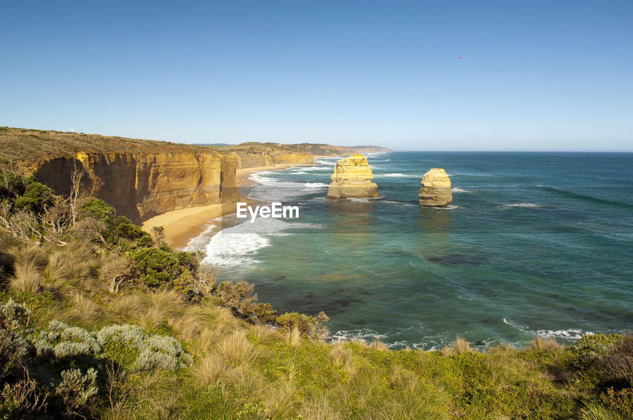 ROCKS IN SEA AGAINST CLEAR SKY