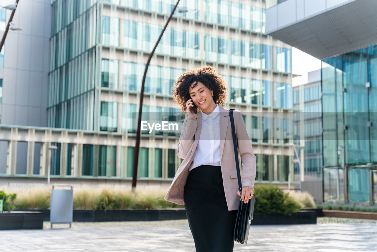 side view of young woman standing against building