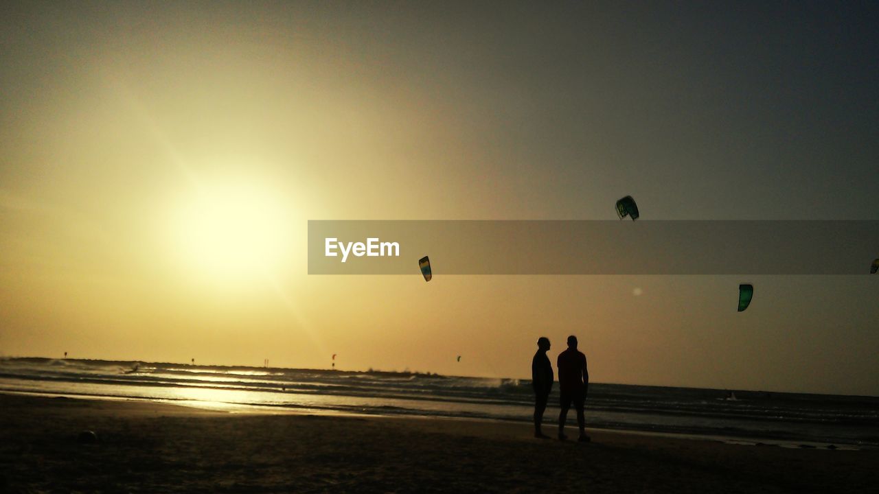 SILHOUETTE PEOPLE ON BEACH AT SUNSET