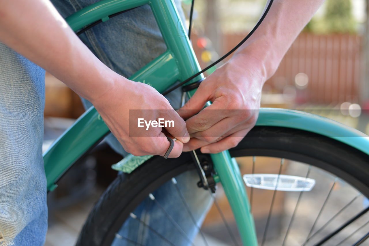 Midsection of man repairing bicycle