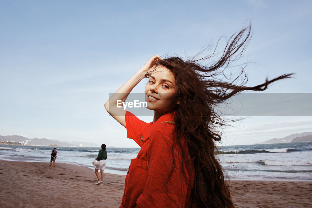 portrait of young woman standing at beach