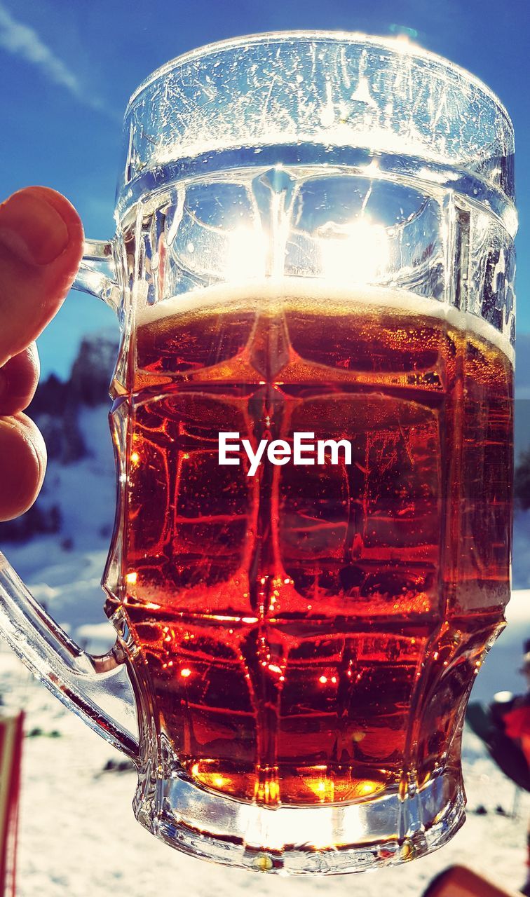 CLOSE-UP OF BEER IN GLASS ON TABLE AGAINST BRIGHT LIGHT