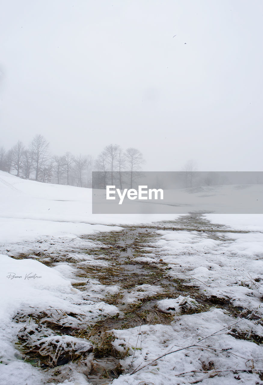 SNOW COVERED LAND AGAINST SKY