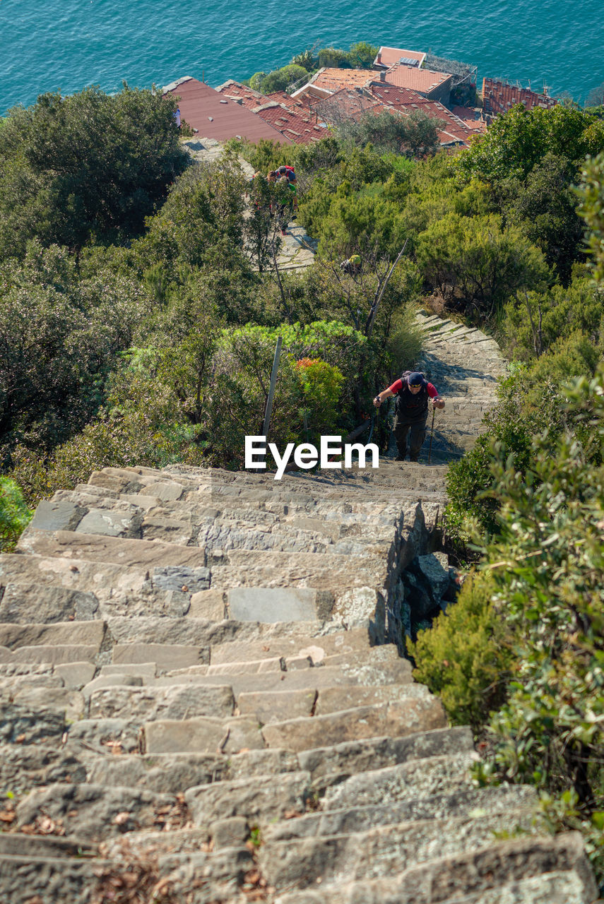 PEOPLE ON ROCKS BY MOUNTAIN