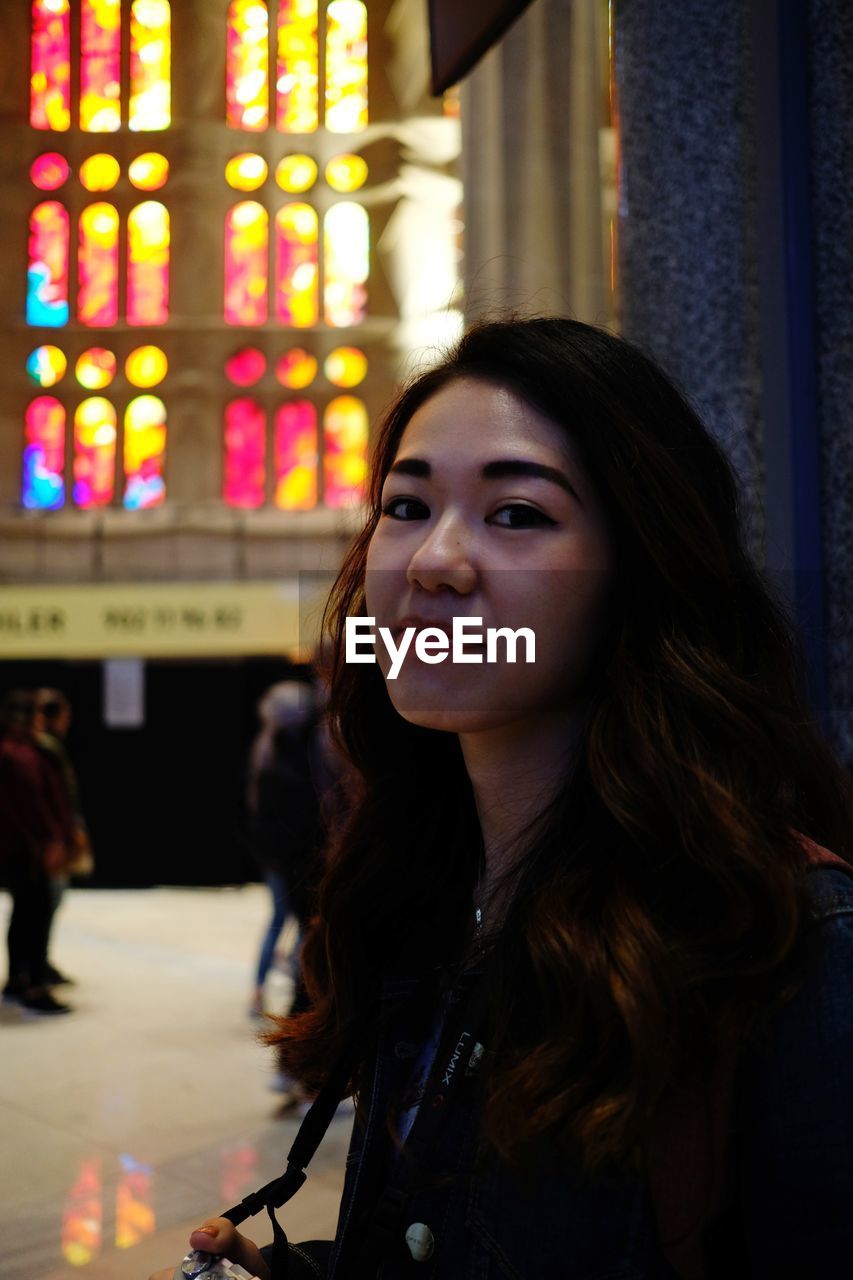 Portrait of young woman standing inside sagrada familia