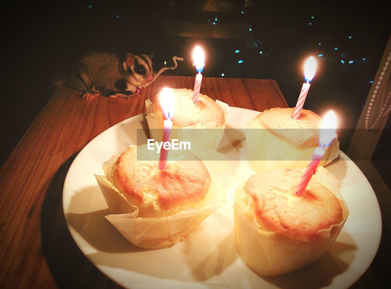 CLOSE-UP OF LIT CANDLES ON TABLE