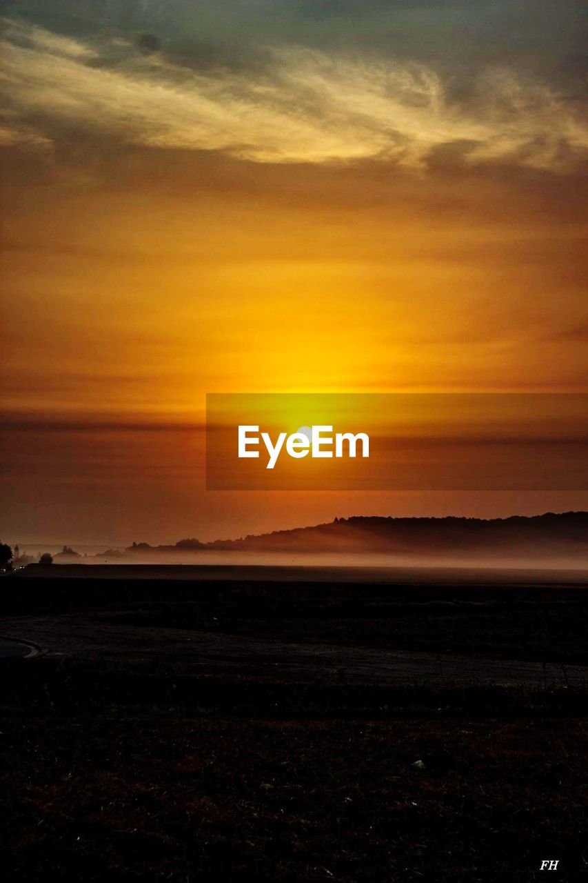 SCENIC VIEW OF SILHOUETTE FIELD AGAINST SKY DURING SUNSET