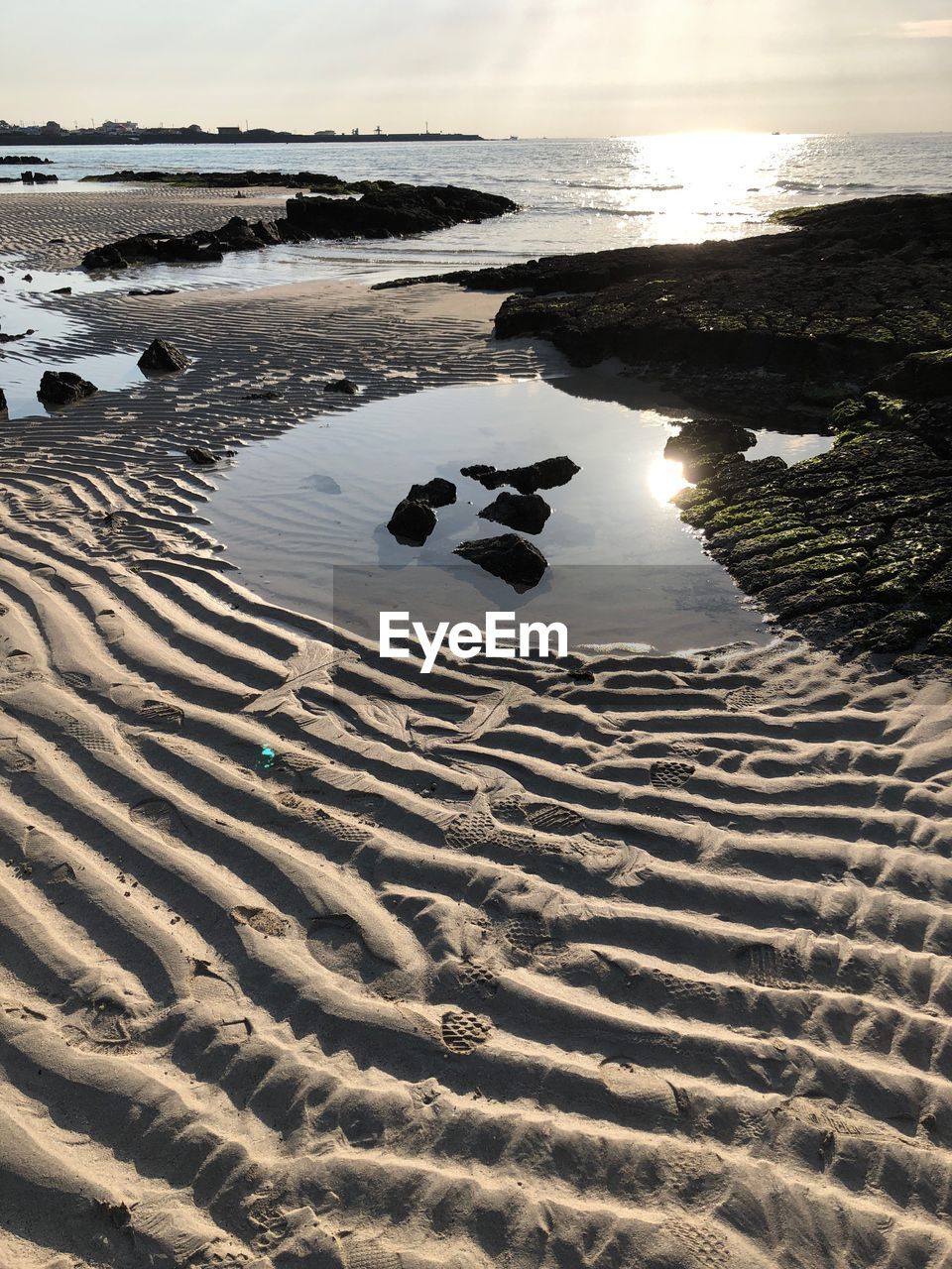 SURFACE LEVEL OF BEACH AGAINST SKY