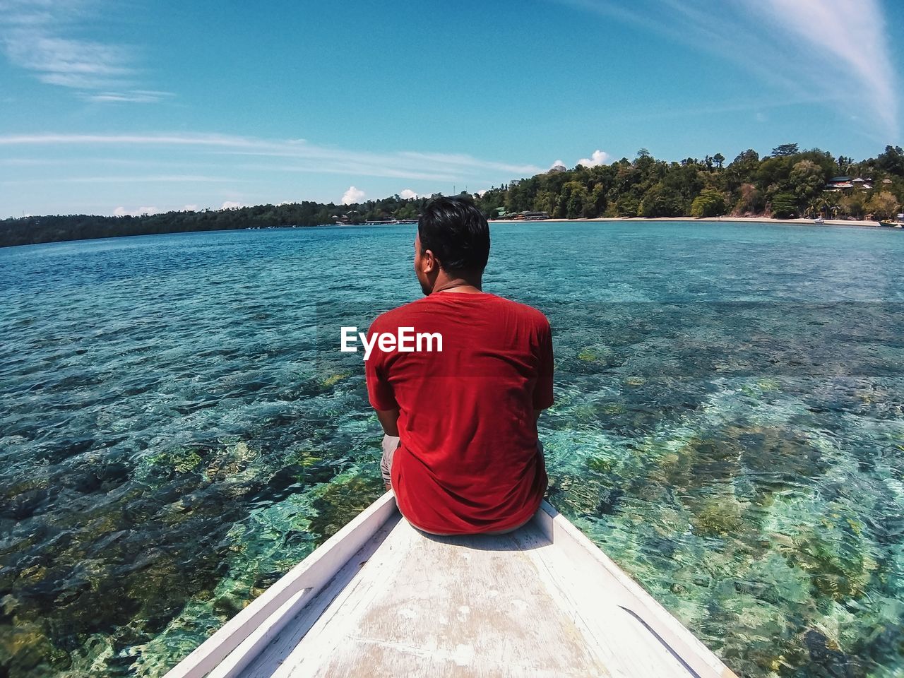 REAR VIEW OF MAN LOOKING AT SEA