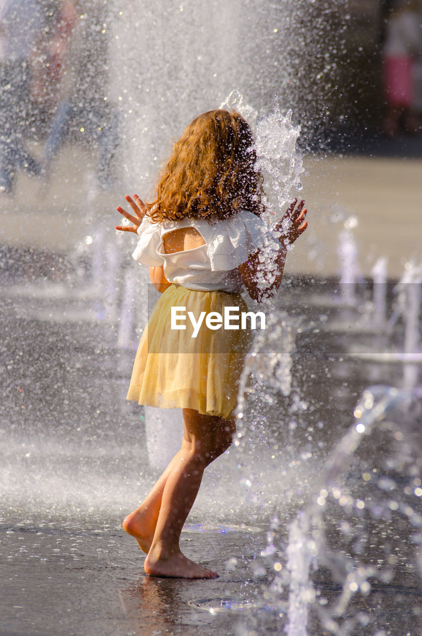 WOMAN STANDING IN WATER