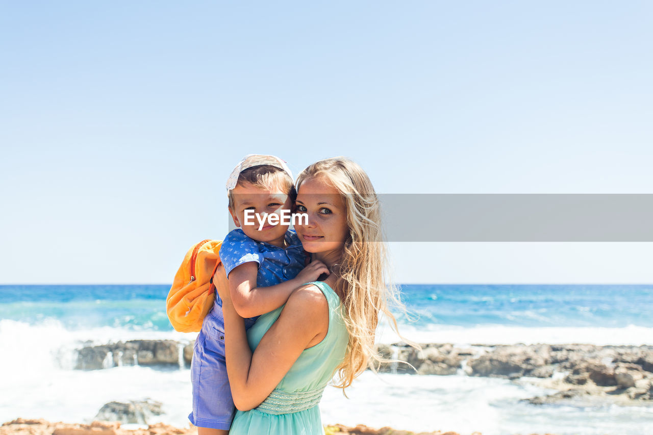 YOUNG COUPLE STANDING ON BEACH