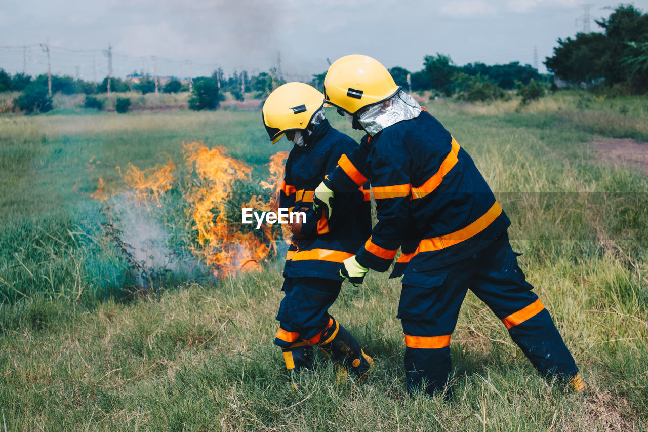 Firefighters by fire on field