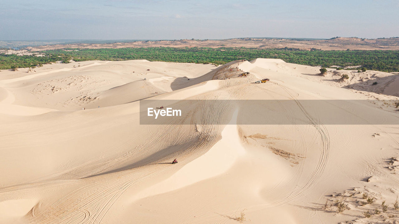 Aerial view of sand dunes at beach against sky